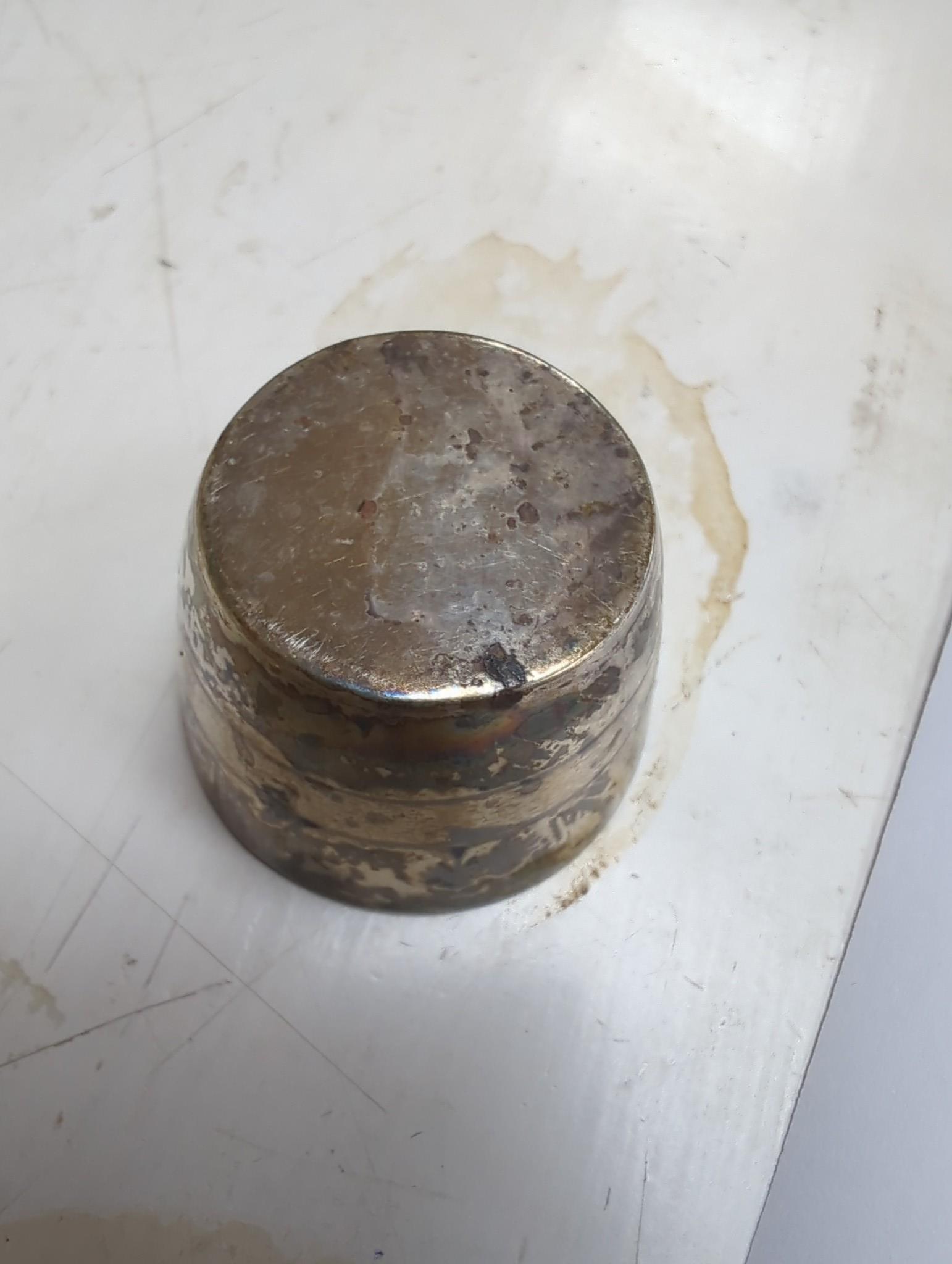 Thirteen assorted Iraq white metal and niello condiments, circular box, five similar napkin rings, a brooch and a pair of similar (damaged) candlesticks.